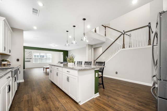810 Corlew St, Murfreesboro, TN 37130 - kitchen with freestanding refrigerator, dark wood-type flooring, a kitchen bar, white cabinetry, and recessed lighting