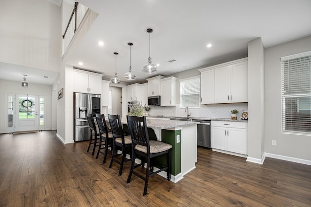 810 Corlew St, Murfreesboro, TN 37130 - kitchen with stainless steel appliances, a kitchen island, dark wood-style flooring, a kitchen breakfast bar, and white cabinetry