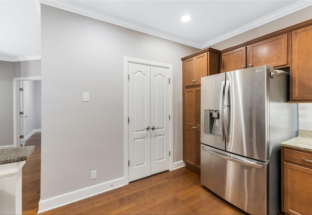 307 Seven Springs Way Unit 103, Brentwood, TN 37027 - kitchen featuring stainless steel fridge, brown cabinets, crown molding, wood finished floors, and stone countertops