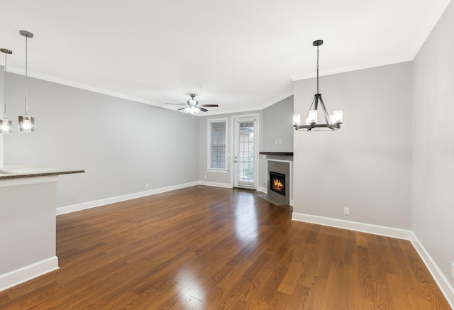 307 Seven Springs Way Unit 103, Brentwood, TN 37027 - unfurnished living room featuring a chandelier, dark wood-style flooring, crown molding, a warm lit fireplace, and a ceiling fan