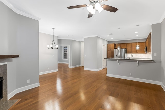307 Seven Springs Way Unit 103, Brentwood, TN 37027 - unfurnished living room with ceiling fan, a tiled fireplace, a chandelier, crown molding, and dark wood finished floors