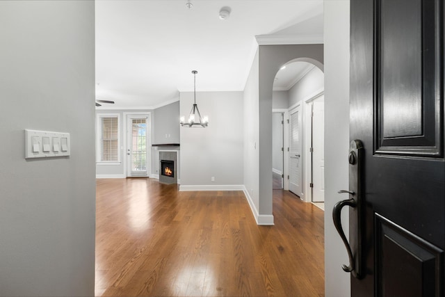 307 Seven Springs Way Unit 103, Brentwood, TN 37027 - foyer entrance with crown molding, wood finished floors, arched walkways, a premium fireplace, and a chandelier