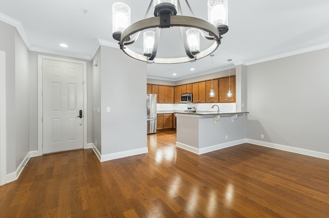 307 Seven Springs Way Unit 103, Brentwood, TN 37027 - kitchen with appliances with stainless steel finishes, a chandelier, brown cabinets, a peninsula, and light countertops