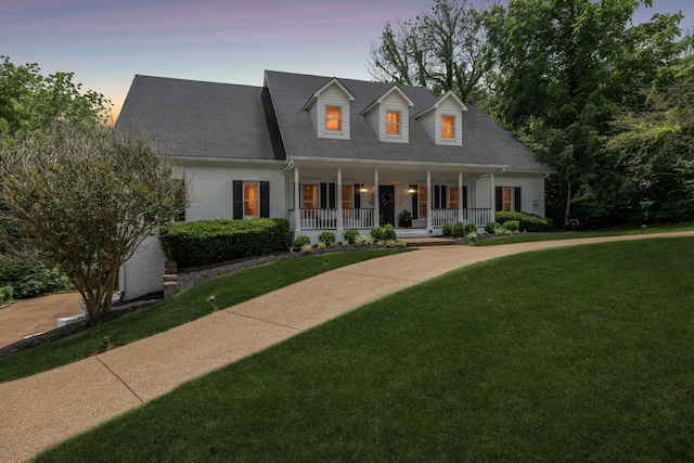 216 Bramerton Ct, Franklin, TN 37069 - cape cod-style house featuring covered porch, a lawn, brick siding, and a shingled roof