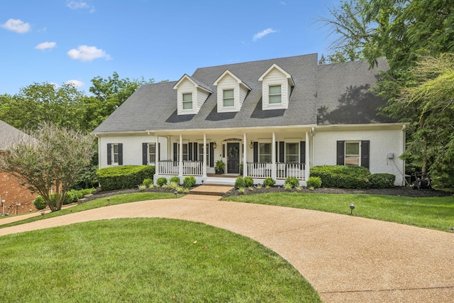 216 Bramerton Ct, Franklin, TN 37069 - cape cod home featuring covered porch, brick siding, a front yard, and roof with shingles