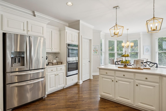 216 Bramerton Ct, Franklin, TN 37069 - kitchen with appliances with stainless steel finishes, a chandelier, ornamental molding, white cabinets, and light countertops