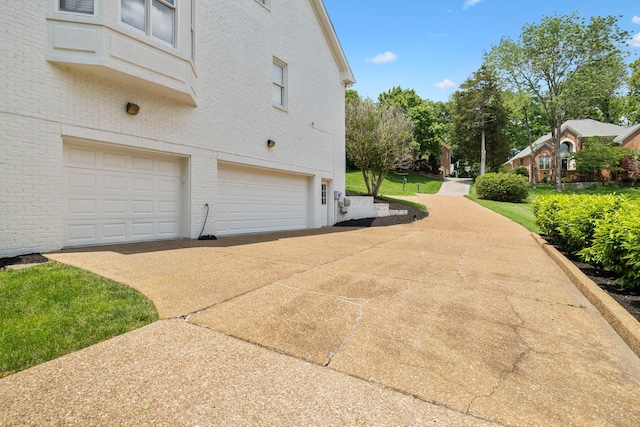 216 Bramerton Ct, Franklin, TN 37069 - view of home's exterior with an attached garage, brick siding, and concrete driveway
