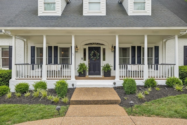216 Bramerton Ct, Franklin, TN 37069 - view of exterior entry featuring covered porch, a shingled roof, and brick siding