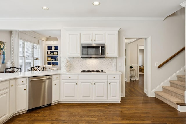 216 Bramerton Ct, Franklin, TN 37069 - kitchen featuring stainless steel appliances, dark wood finished floors, decorative backsplash, ornamental molding, and light countertops