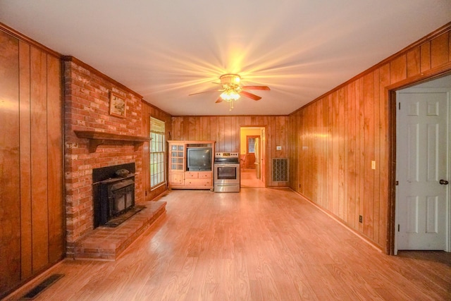 1094B Center Point Rd, Hendersonville, TN 37075 - unfurnished living room featuring wood walls, light wood-type flooring, ceiling fan, a fireplace, and crown molding