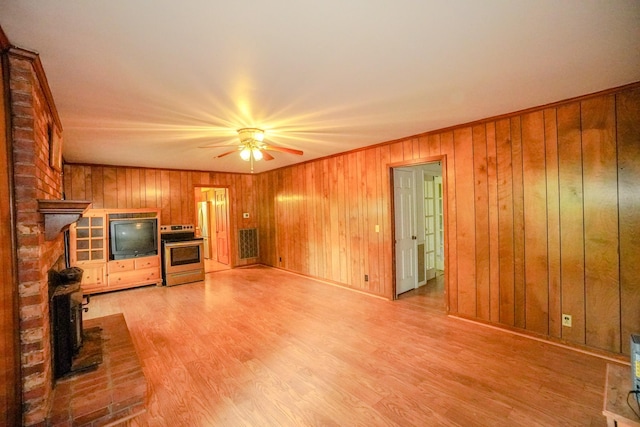 1094B Center Point Rd, Hendersonville, TN 37075 - unfurnished living room featuring a wood stove, a ceiling fan, light wood finished floors, and wooden walls
