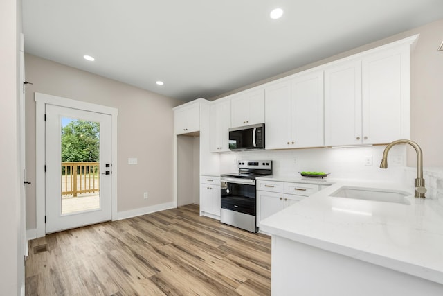 223 Patriot Ln, Estill Springs, TN 37330 - kitchen featuring stainless steel appliances, light wood-type flooring, decorative backsplash, white cabinetry, and recessed lighting