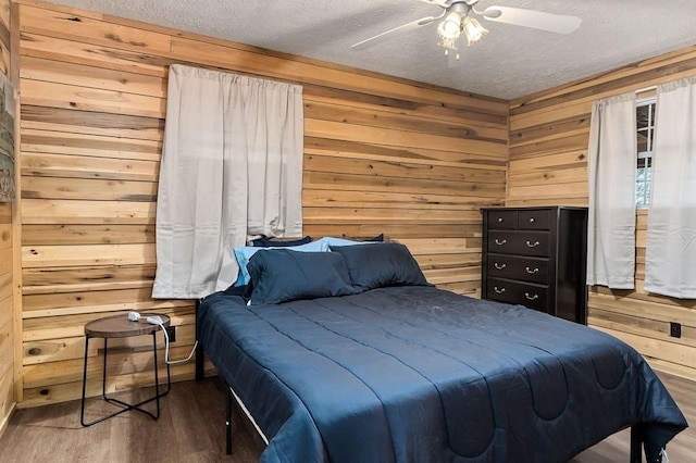 7769 Willow Grove Hwy, Allons, TN 38541 - bedroom featuring a textured ceiling, wood walls, wood finished floors, and a ceiling fan