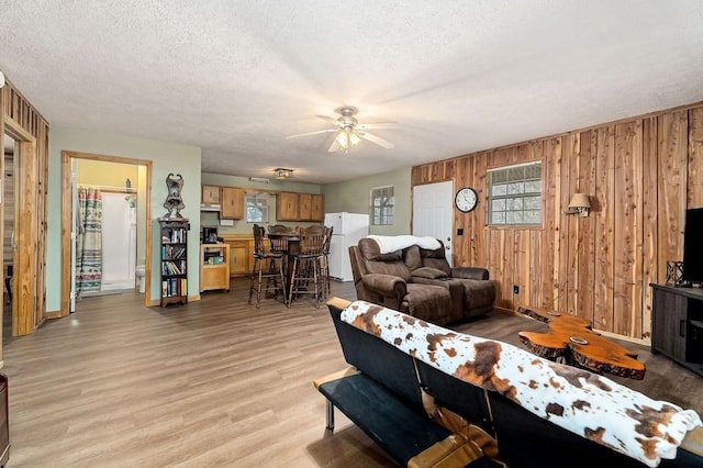 7769 Willow Grove Hwy, Allons, TN 38541 - living room with ceiling fan, wooden walls, a textured ceiling, and light wood-style floors