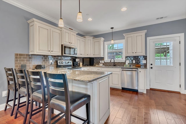 4313 Glasgow Rd, Spring Hill, TN 37174 - kitchen with stainless steel appliances, a peninsula, wood-type flooring, light stone counters, and decorative backsplash
