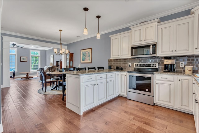4313 Glasgow Rd, Spring Hill, TN 37174 - kitchen featuring appliances with stainless steel finishes, a peninsula, decorative backsplash, crown molding, and hanging light fixtures