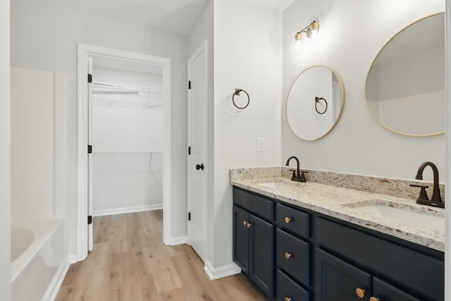 2717 Cayuga Dr, Murfreesboro, TN 37130 - bathroom with wood finished floors, double vanity, a bath, and a walk in closet