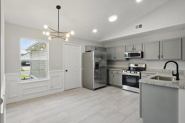 2717 Cayuga Dr, Murfreesboro, TN 37130 - kitchen with appliances with stainless steel finishes, gray cabinets, light stone counters, a chandelier, and lofted ceiling