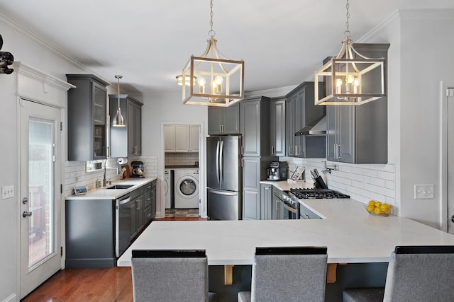 2507 Patricia Cir, Murfreesboro, TN 37128 - kitchen with stainless steel appliances, a chandelier, washing machine and dryer, gray cabinets, and ornamental molding
