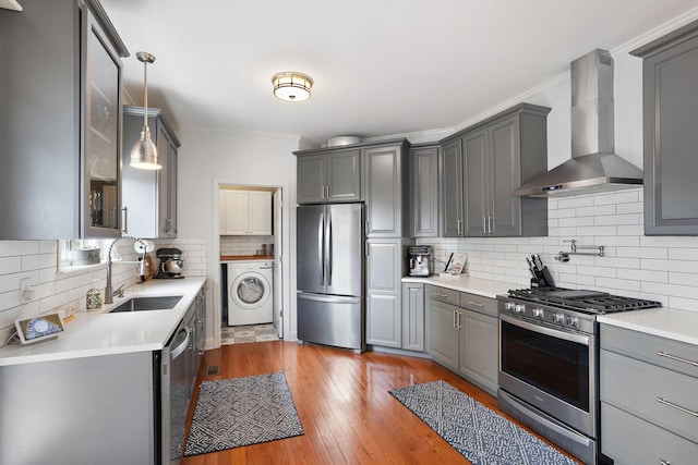 2507 Patricia Cir, Murfreesboro, TN 37128 - kitchen featuring stainless steel appliances, wall chimney range hood, washer / dryer, gray cabinetry, and tasteful backsplash