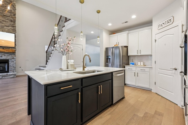 6807 Kew Gdn, Smyrna, TN 37167 - kitchen with appliances with stainless steel finishes, white cabinets, light wood-style flooring, an island with sink, and pendant lighting