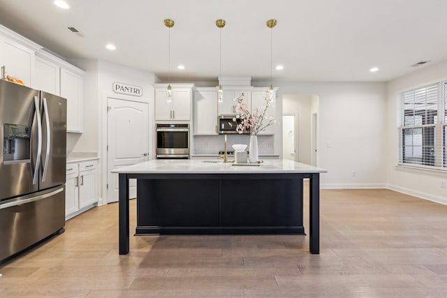 6807 Kew Gdn, Smyrna, TN 37167 - kitchen with stainless steel appliances, decorative backsplash, white cabinets, recessed lighting, and a kitchen island with sink
