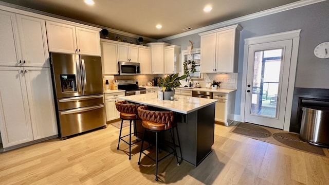 1248 Hensfield Dr, Murfreesboro, TN 37128 - kitchen with stainless steel appliances, light wood finished floors, ornamental molding, a kitchen breakfast bar, and backsplash