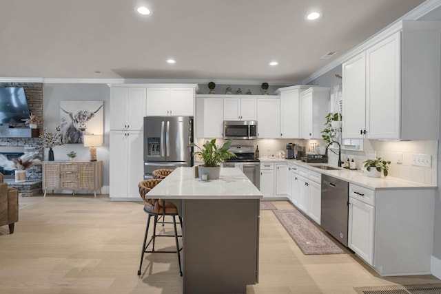 1248 Hensfield Dr, Murfreesboro, TN 37128 - kitchen with appliances with stainless steel finishes, ornamental molding, light wood finished floors, a kitchen island, and recessed lighting
