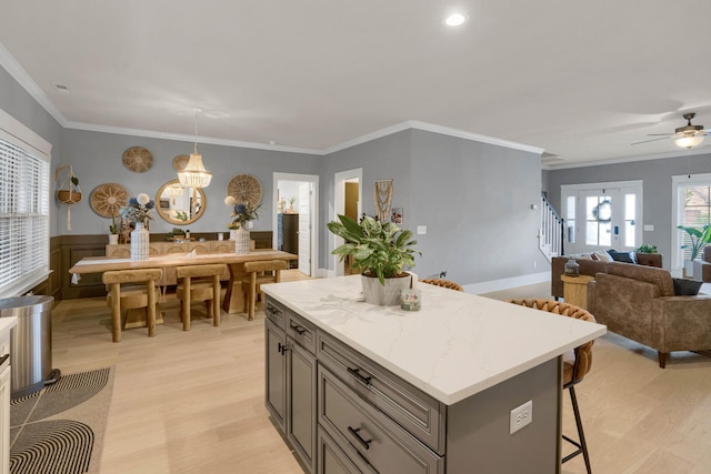 1248 Hensfield Dr, Murfreesboro, TN 37128 - kitchen featuring a breakfast bar area, light wood-style flooring, open floor plan, a kitchen island, and crown molding
