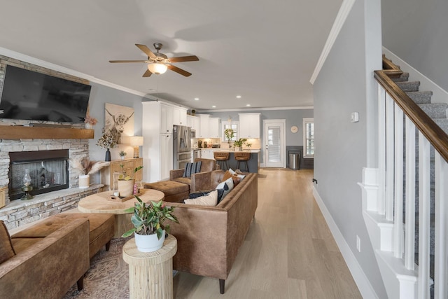 1248 Hensfield Dr, Murfreesboro, TN 37128 - living room featuring crown molding, light wood-style flooring, stairway, ceiling fan, and a stone fireplace