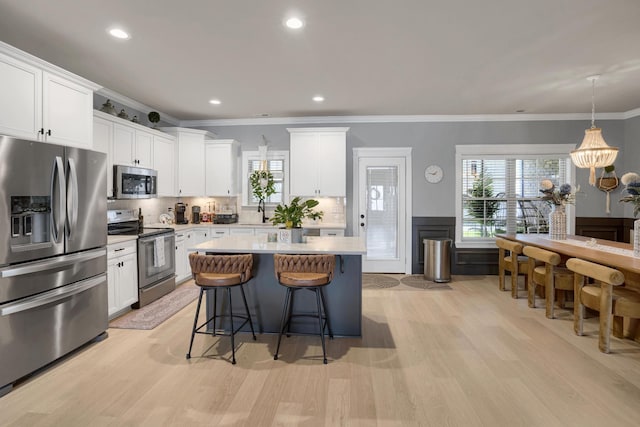 1248 Hensfield Dr, Murfreesboro, TN 37128 - kitchen with appliances with stainless steel finishes, a breakfast bar, light wood-style flooring, a center island, and light countertops