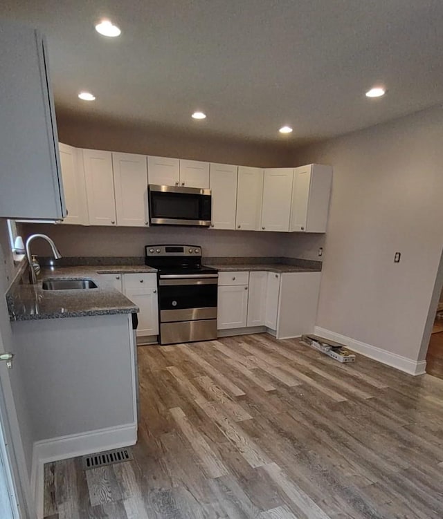 918 Velma Ln, Murfreesboro, TN 37129 - kitchen featuring stainless steel appliances, white cabinets, wood finished floors, dark stone countertops, and recessed lighting