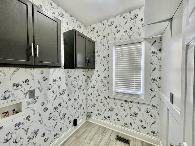 3325 Geneva Dr, Murfreesboro, TN 37128 - laundry room with wallpapered walls, light wood-style floors, and cabinet space