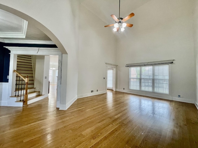 3325 Geneva Dr, Murfreesboro, TN 37128 - unfurnished living room with ceiling fan, wood finished floors, high vaulted ceiling, arched walkways, and stairs