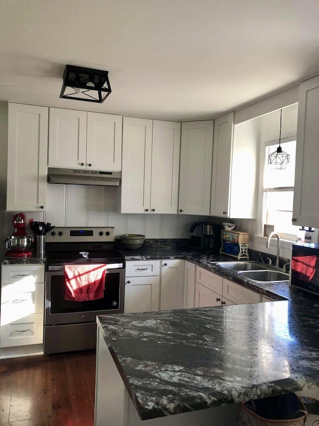 1109 N Charlotte St, Dickson, TN 37055 - kitchen with stainless steel electric stove, under cabinet range hood, dark wood-style flooring, a peninsula, and dark stone countertops