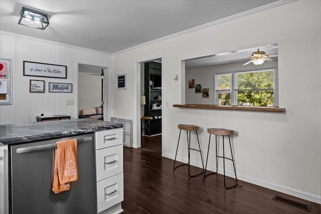 1109 N Charlotte St, Dickson, TN 37055 - kitchen with stainless steel dishwasher, ornamental molding, ceiling fan, dark wood finished floors, and white cabinetry