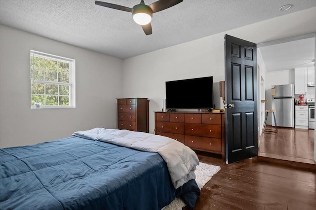 1109 N Charlotte St, Dickson, TN 37055 - bedroom with freestanding refrigerator, dark wood-style floors, a textured ceiling, and a ceiling fan