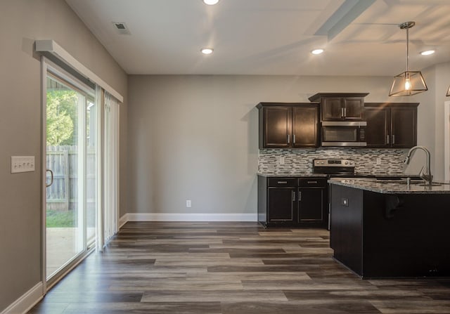 203 Eagles Talon Ct, Clarksville, TN 37040 - kitchen featuring appliances with stainless steel finishes, dark stone countertops, decorative backsplash, dark wood-style flooring, and recessed lighting