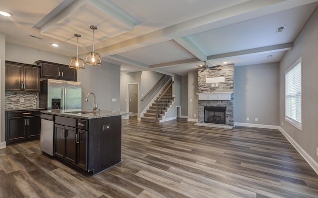 203 Eagles Talon Ct, Clarksville, TN 37040 - kitchen featuring stainless steel appliances, backsplash, a stone fireplace, light stone countertops, and dark wood-style flooring