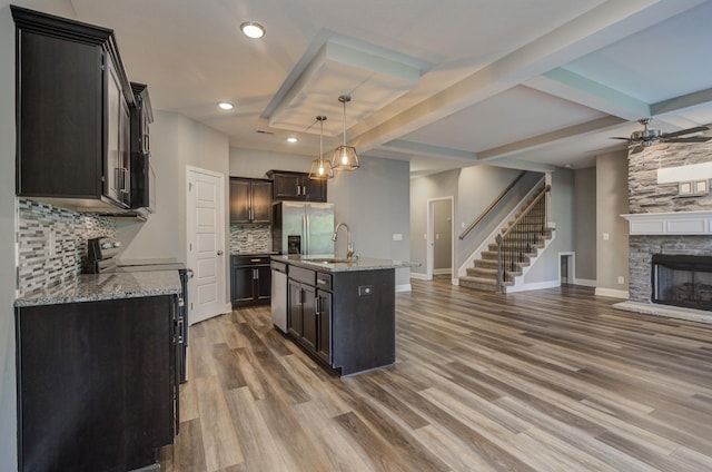 203 Eagles Talon Ct, Clarksville, TN 37040 - kitchen featuring stainless steel appliances, open floor plan, a fireplace, backsplash, and wood finished floors