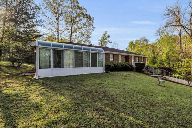 6434 Waconda Point Rd, Harrison, TN 37341 - back of house with a sunroom, a lawn, and brick siding