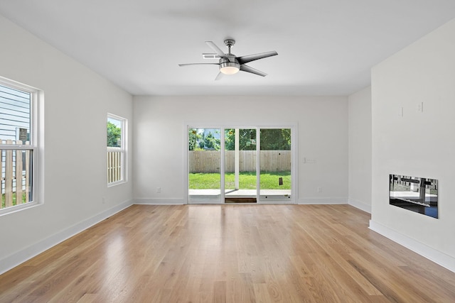 2140 18th Ave N, Nashville, TN 37208 - unfurnished living room featuring heating unit, light wood-style flooring, and ceiling fan