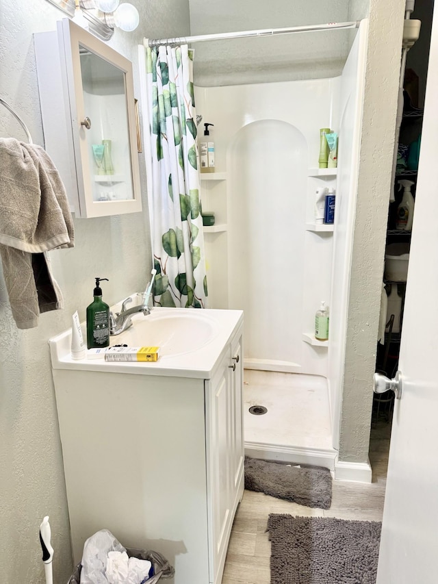 1812 13th St E, Chattanooga, TN 37404 - full bathroom with a shower stall, vanity, wood finished floors, and a textured wall