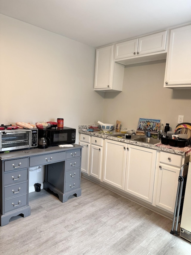 1812 13th St E, Chattanooga, TN 37404 - kitchen featuring light wood-style floors, white cabinetry, gray cabinets, and black microwave