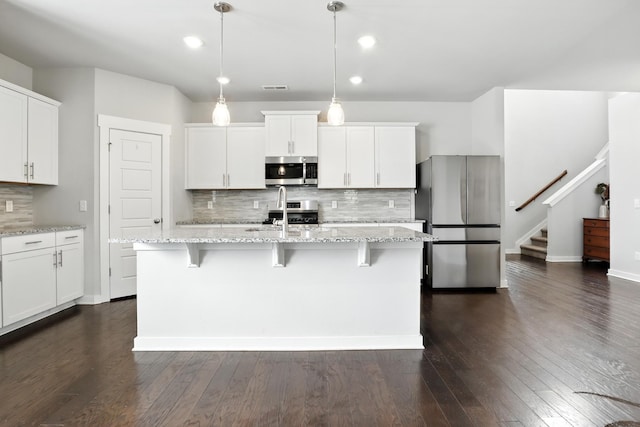 3154 Rift Ln, Murfreesboro, TN 37130 - kitchen with appliances with stainless steel finishes, tasteful backsplash, a kitchen bar, white cabinetry, and dark wood-style flooring