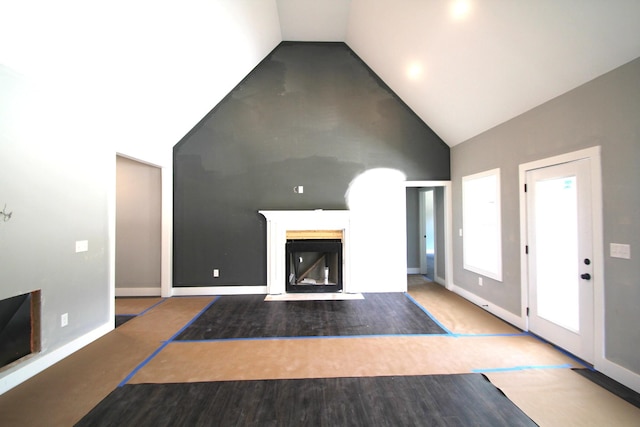 333 Brinkley Rd, Wartrace, TN 37183 - unfurnished living room with high vaulted ceiling, a fireplace with flush hearth, and wood finished floors