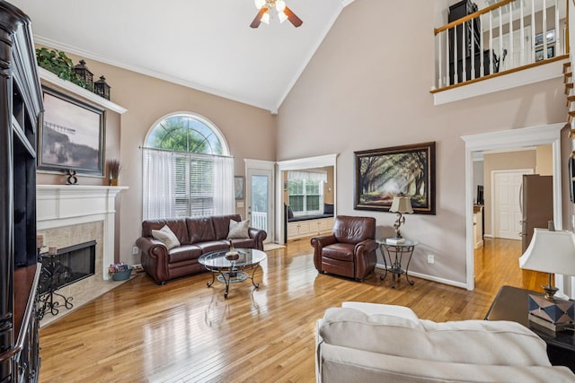 1011 Brixworth Dr, Thompsons Station, TN 37179 - living area with ceiling fan, a tile fireplace, ornamental molding, high vaulted ceiling, and wood finished floors