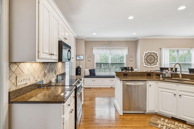 1011 Brixworth Dr, Thompsons Station, TN 37179 - kitchen featuring stainless steel appliances, plenty of natural light, ornamental molding, white cabinets, and recessed lighting