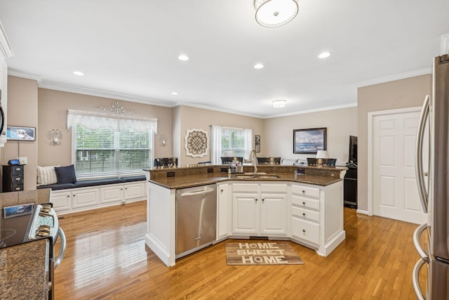 1011 Brixworth Dr, Thompsons Station, TN 37179 - kitchen with appliances with stainless steel finishes, light wood-style flooring, ornamental molding, white cabinets, and open floor plan