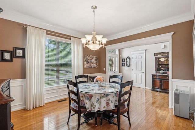 1011 Brixworth Dr, Thompsons Station, TN 37179 - dining space featuring a chandelier, light wood-type flooring, crown molding, wainscoting, and a decorative wall